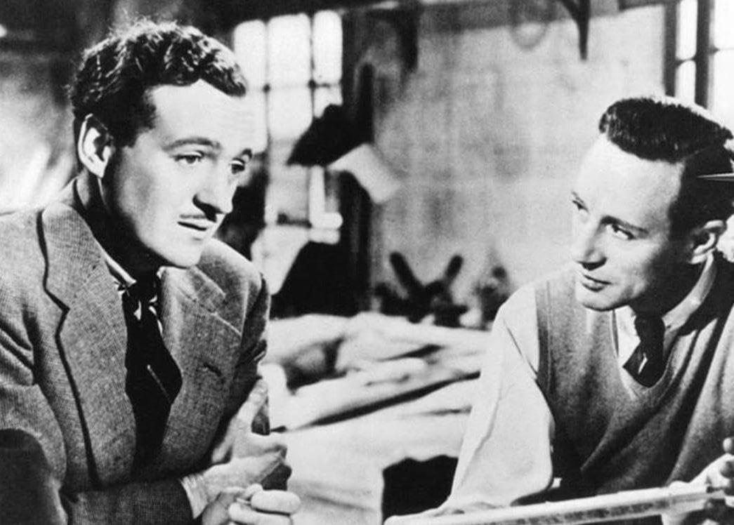 Geoffrey Crisp (David Niven, L) talks about his post-World War I hardships with his friend R.J. Mitchell (Leslie Howard), in “Spitfire.” (General Film Distributors)