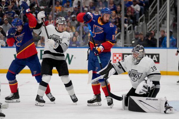 A puck bounces off Los Angeles Kings goaltender Cam Talbot (39) as Kings' Jordan Spence (21) watches along with St. Louis Blues' Kevin Hayes (12) and Brandon Saad (L) watch during the second period of an NHL hockey game in St. Louis on March 13, 2024. (Jeff Roberson/AP Photo)