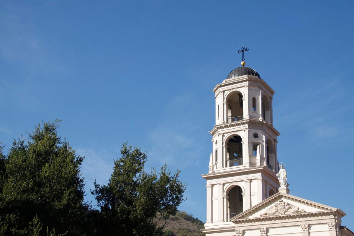 The bell tower rises to 135 feet. Three large brass bells ring three times daily over the rural landscape through arched openings within nested levels. Dental moldings surround the base of each level. (Courtesy of Thomas Aquinas College)