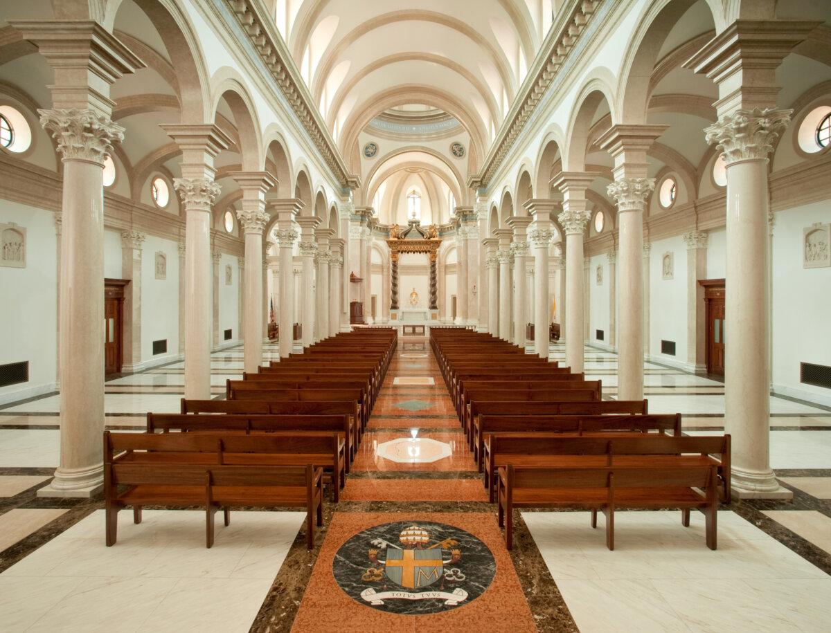 With seating for 700, the chapel reflects its classical roots with the 31-foot-high columns on each side of the nave. The columns support and accentuate the majestic barrel ceiling. For earthquake protection, full-length steel bars were inserted into nine-inch holes in the center of the columns. The decorative marble flooring features Latin phrases and coats of arms. (Courtesy of Thomas Aquinas College)