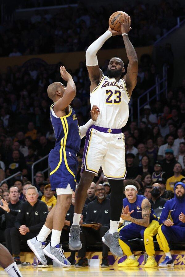 LeBron James (23) of the Los Angeles Lakers shoots a three point shot past the defense of Chris Paul (3) of the Golden State Warriors during the first half of a game in Los Angeles on March 16, 2024. (Sean M. Haffey/Getty Images)