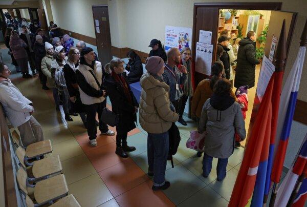 People stand in a line to enter a polling station at about noon on the final day of the presidential election in the town of Kudrovo, Russia, on March 17, 2024. (Anton Vaganov/Reuters)