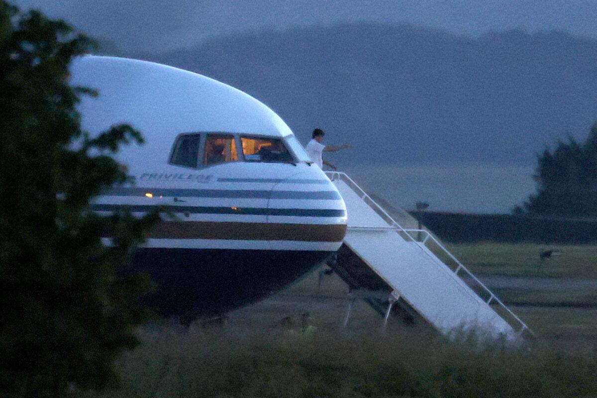 The pilot gives a thumbs up on the steps of the Rwanda deportation flight EC-LZO Boeing 767 at Boscombe Down Air Base, England, on June 14, 2022. The Court of Appeal the day before rejected a legal bid to stop a Home Office flight taking asylum seekers from the UK to Rwanda. (Dan Kitwood/Getty Images)