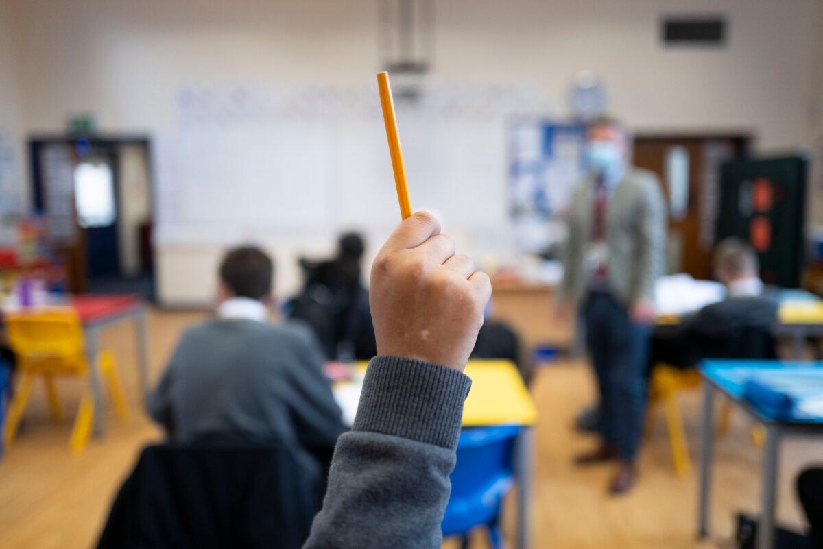 A pupil raises their hand during a lesson at Whitchurch High School in Cardiff, Wales, on Sept. 14, 2021. (Matthew Horwood/Getty Images)