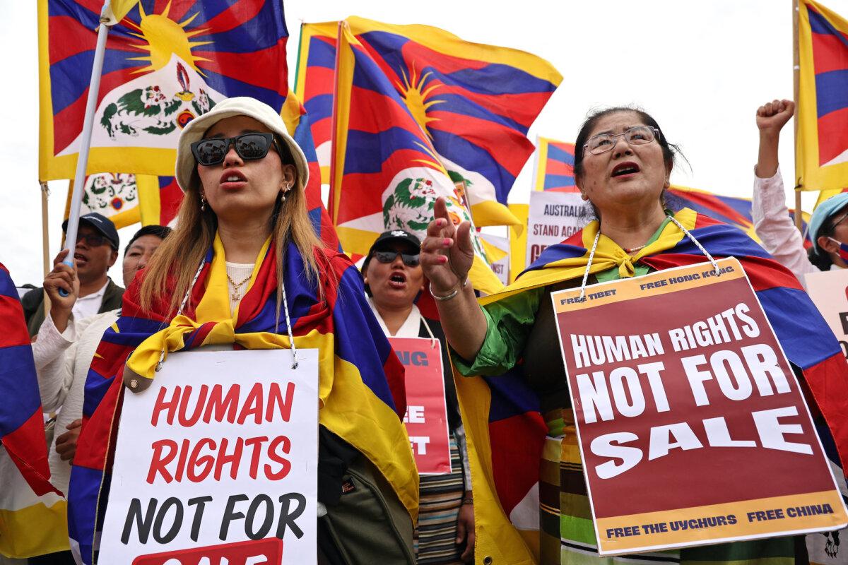 Members of the Australian Tibetan community hold flags and placards as they protest at a rally organized by the Alliance for Victims of the Chinese Communist Regime outside Parliament House in Canberra on March 20, 2024. (David Gray/AFP via Getty Images)