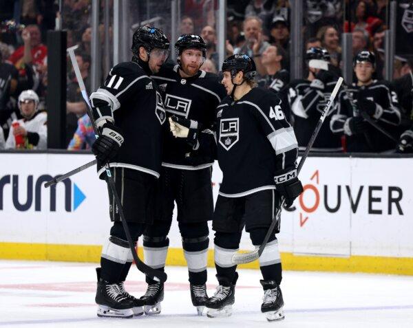 Vladislav Gavrikov (84) of the Los Angeles Kings celebrates his goal with Anze Kopitar (11) abd Blake Lizotte (46), to take a over the Chicago Blackhawks, during the second period in Los Angeles on March 19, 2024. (Harry How/Getty Images)