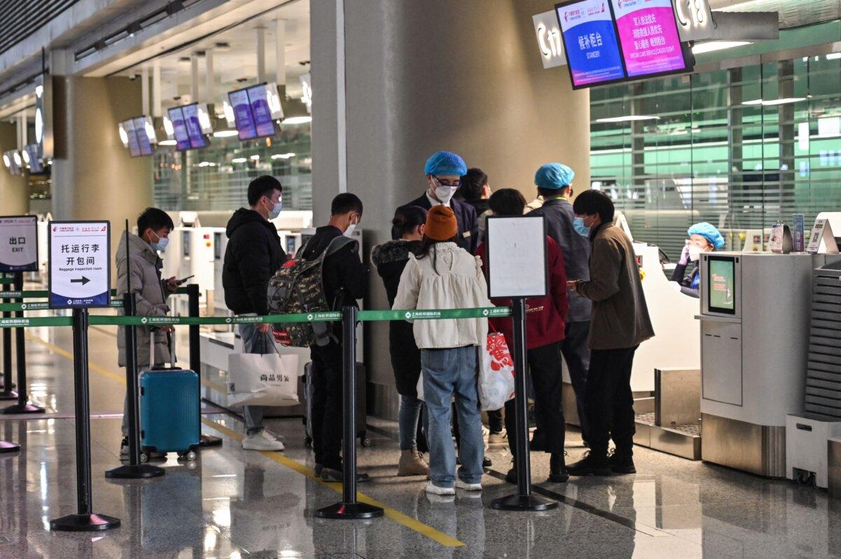 People stand at the check-in counters of China Eastern Airlines in Hongqiao International Airport in Shanghai on March 21, 2022. (Hector Retamal/AFP via Getty Images)