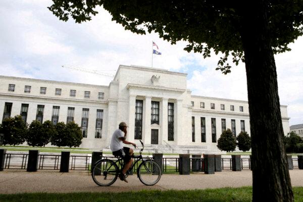 A cyclist passes the Federal Reserve building in Washington on Aug. 22, 2018. (Chris Wattie/Reuters)