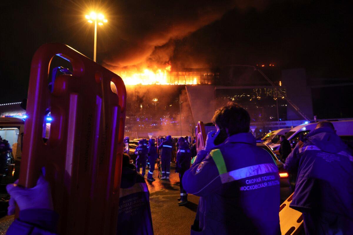 A medic stands near ambulances parked outside the burning building of the Crocus City Hall on the western edge of Moscow, Russia, on March 22, 2024. (AP Photo/Vitaly Smolnikov)