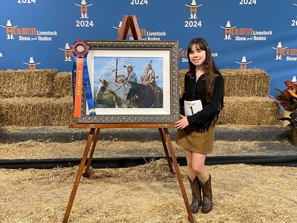 The artist poses beside her grand prize-winning painting, "Warriors of the Great Spirit." (Courtesy of The Hoffmans)
