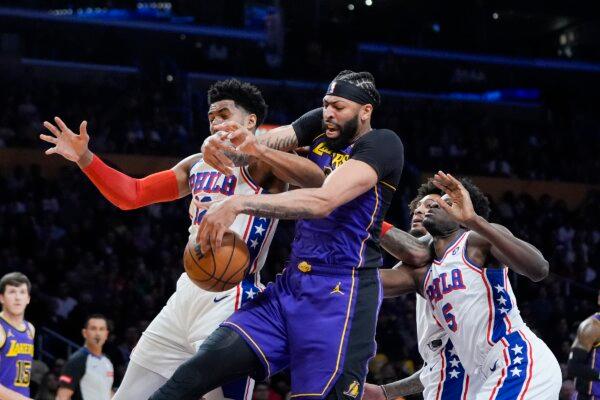 Los Angeles Lakers forward Anthony Davis (C) and Philadelphia 76ers forward Tobias Harris (L) vie for a rebound during the first half of an NBA basketball game in Los Angeles on March 22, 2024. (Jae C. Hong/AP Photo)