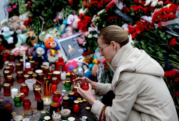 Former Top General Warns of ‘Inevitable’ ISIS Terrorist Threat in US | USNN World News A woman lights a candle at a memorial to the victims of a March 22, 2024, shooting attack at the Crocus City Hall concert venue in Moscow, on March 24, 2024. (Maxim Shemetov/Reuters)
