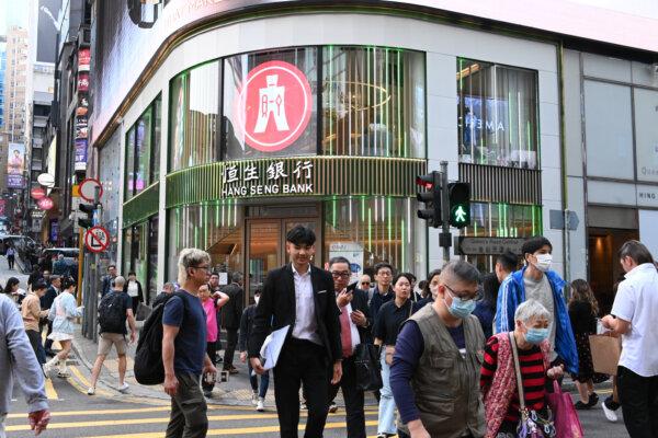 People walk past Hang Seng Bank in Central Hong Kong on Jan. 19, 2024. (Bill Cox/The Epoch Times)