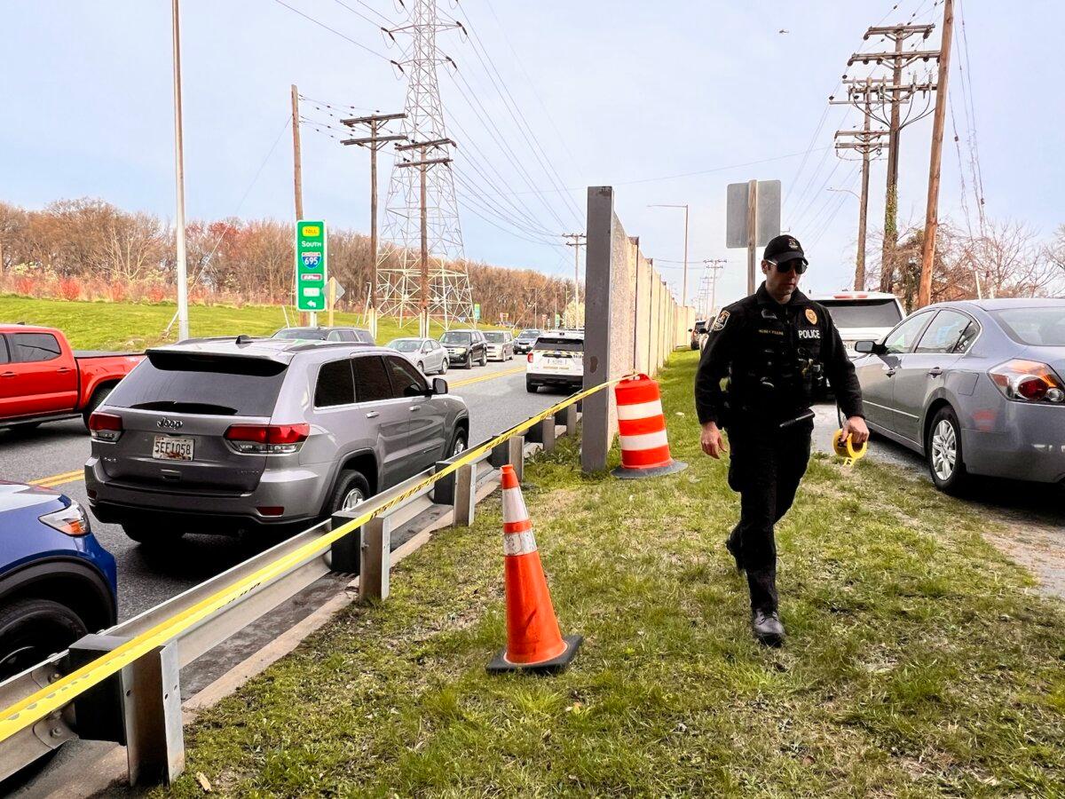 Police officers add do not cross yellow tape nearby the Francis Scott Key Bridge in Baltimore on March 26, 2024. (Madalina Vasiliu/The Epoch Times)