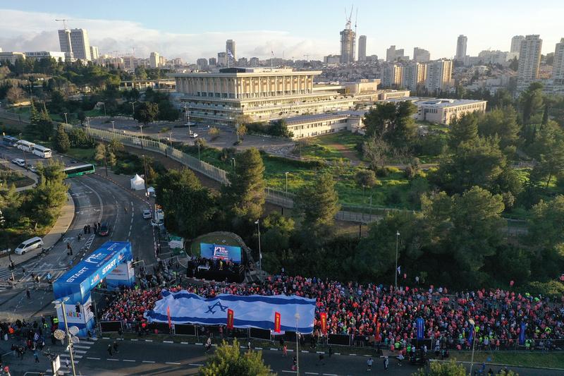 Runners unfurl a giant Israeli flag at the start of the Jerusalem Marathon on March 8, 2024. (Alternativa 1)