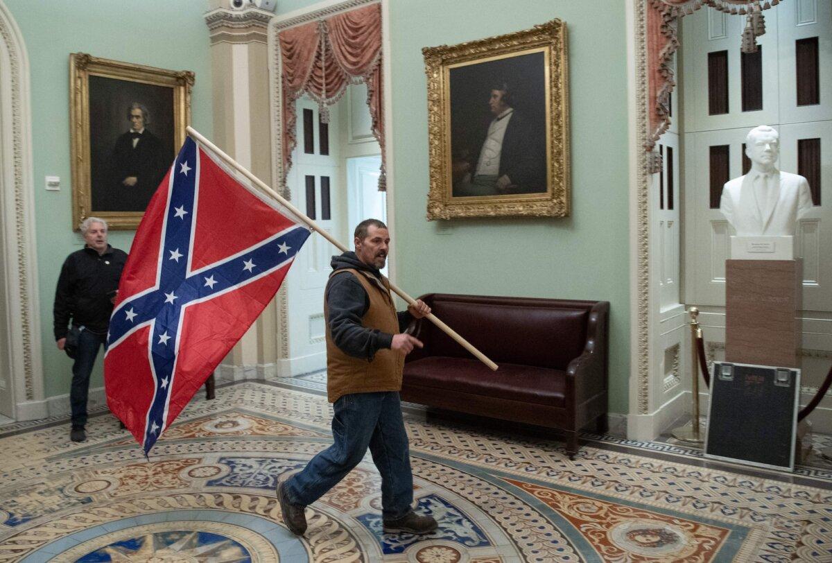 Kevin Seefried holds a Confederate flag outside the Senate Chamber during a protest after breaching the U.S. Capitol, in Washington, on Jan. 6, 2021. (Saul Loeb/AFP/Getty Images)