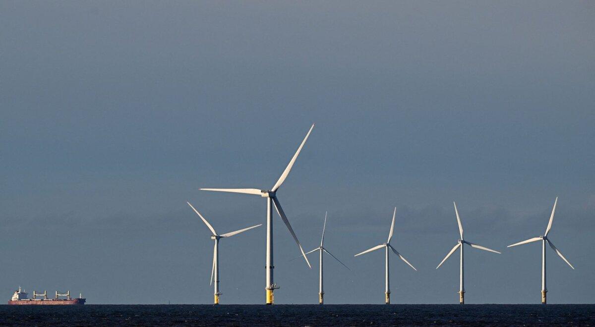 Bulk Carrier Kiran Marmara makes it way towards port in Liverpool, northwest England, passing wind turbines in the Burbo Bank wind farm in the Irish Sea, on Nov. 21, 2023. (Paul Ellis/AFP via Getty Images)