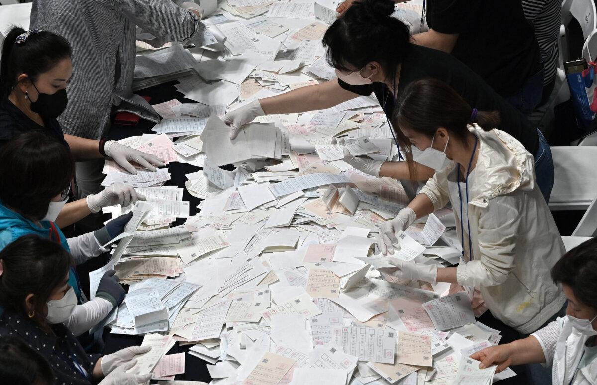 Les responsables électoraux sud-coréens comptent les bulletins de vote pour les élections locales nationales pour élire les maires, les gouverneurs, les membres des conseils locaux et les chefs régionaux de l'éducation à Séoul, le 1er juin 2022. (Jung Yeon-je/AFP via Getty Images)