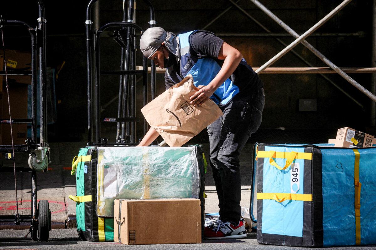 An Amazon delivery worker sorts packages out for delivery in the financial district of New York City on Oct. 11, 2022. (Brendan McDermid/Reuters)