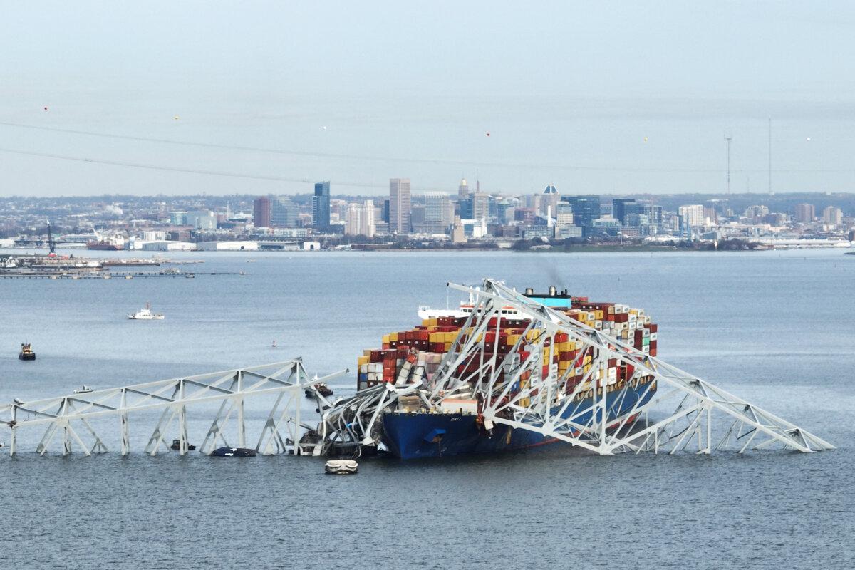 The steel frame of the Francis Scott Key Bridge sits on top of a container ship after the bridge collapsed, Baltimore, Md., on March 26, 2024. (Jim Watson/AFP via Getty Images)