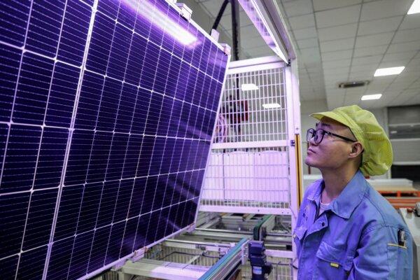 A worker examines solar photovoltaic modules used for solar panels at a workshop in Huaian city, in eastern China's Jiangsu province, on Sept. 5, 2023. (STR/AFP via Getty Images)