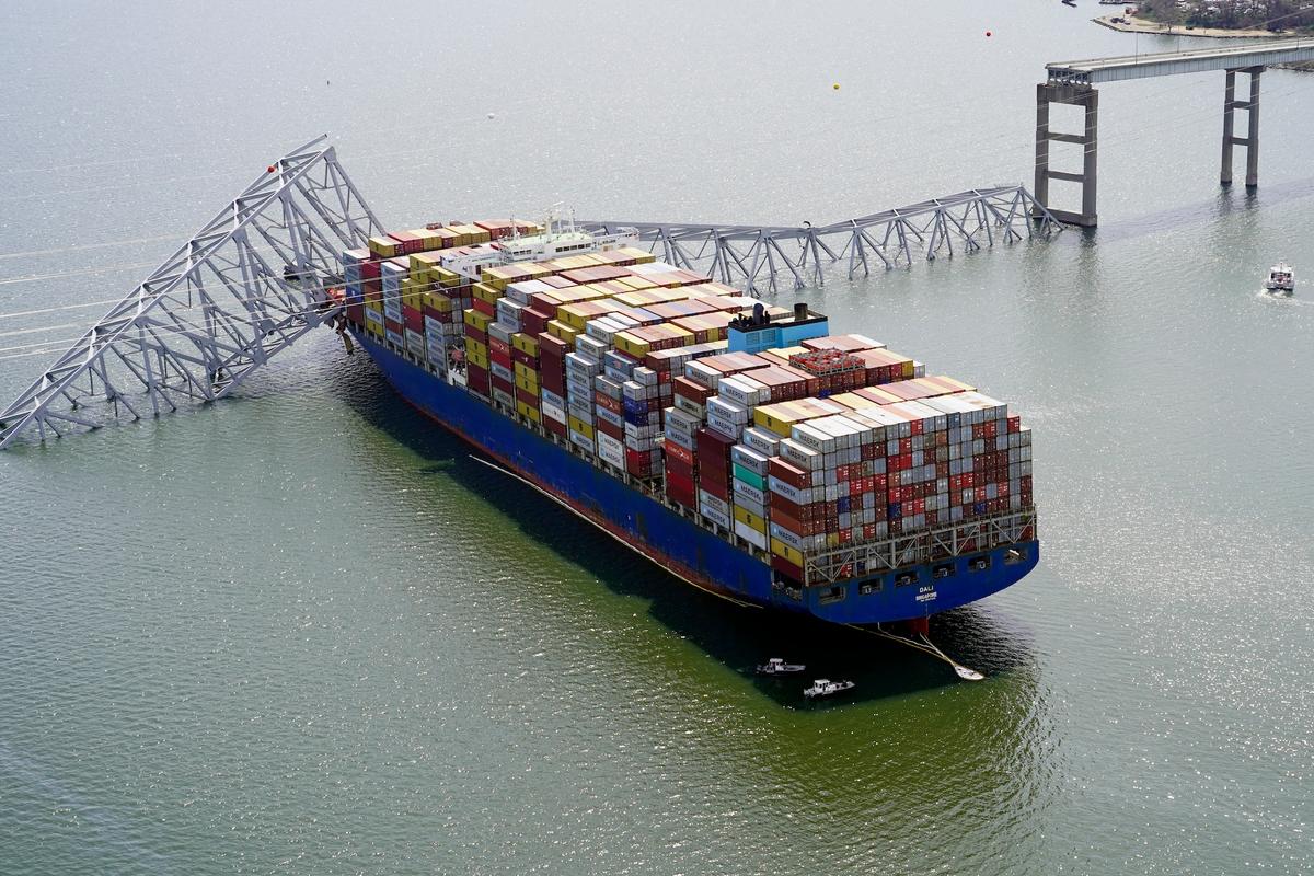 The cargo ship Dali is stuck under part of the structure of the Francis Scott Key Bridge after the ship hit the bridge in Baltimore on March 26, 2024. (Maryland National Guard via AP, File)