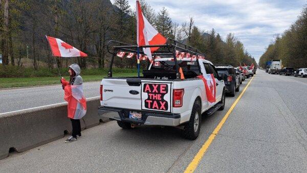An anti-carbon tax protester waves a flag near Hope, B.C., on April 1, 2024. (Jeff Sandes/The Epoch Times)
