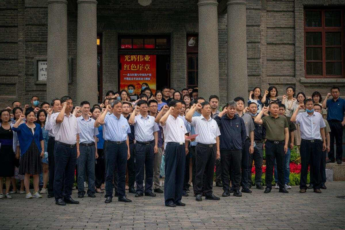 Visitors take an oath in front of a communist flag (not seen) at the entrance of Peking University's Red Building, where a new exhibition has been set up as part of the celebrations of the 100th anniversary of the Communist Party of China, on June 30, 2021. (Andrea Verdelli/Getty Images)