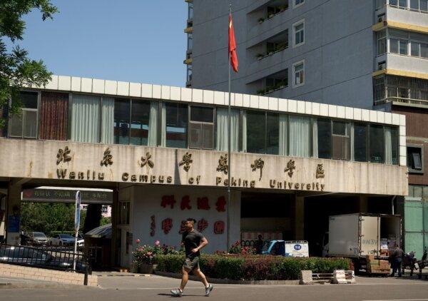 A man jogs in front of the Wanliu campus of Peking University in Beijing on May 16, 2022. (Noel Celis/AFP via Getty Images)