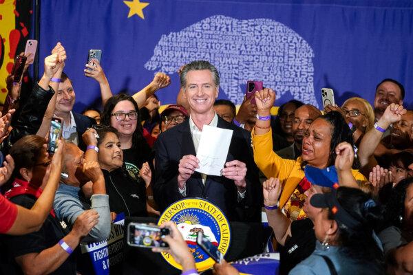California Gov. Gavin Newsom signs the fast-food bill surrounded by fast food workers at the SEIU Local 721 in Los Angeles, Calif., on Sept. 28, 2023. (Damian Dovarganes/AP Photo)