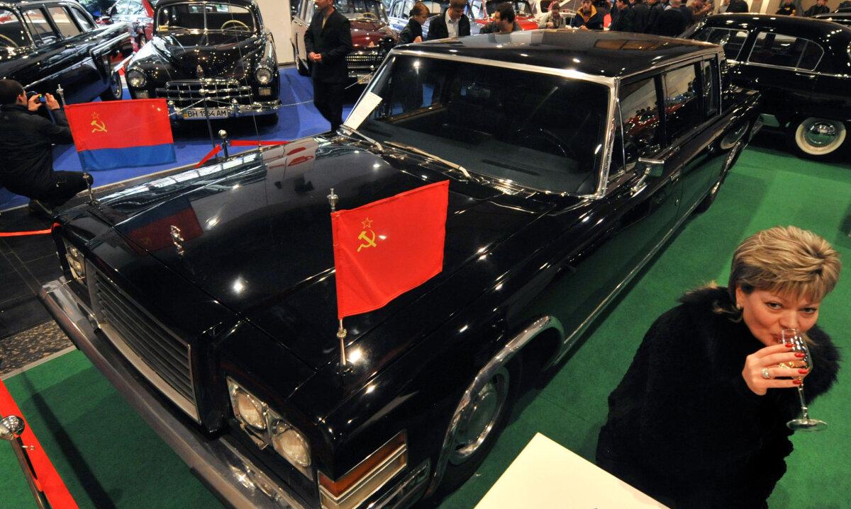 A visiter drinks wine near a Soviet luxury car ZIL-150 belonging to Ukrainian former Communist Party leader Volodymyr Sherbitsky at the Retro and Exotic Motor Show in Kiev on April 16, 2010. (Sergei Supinsky/AFP via Getty Images)