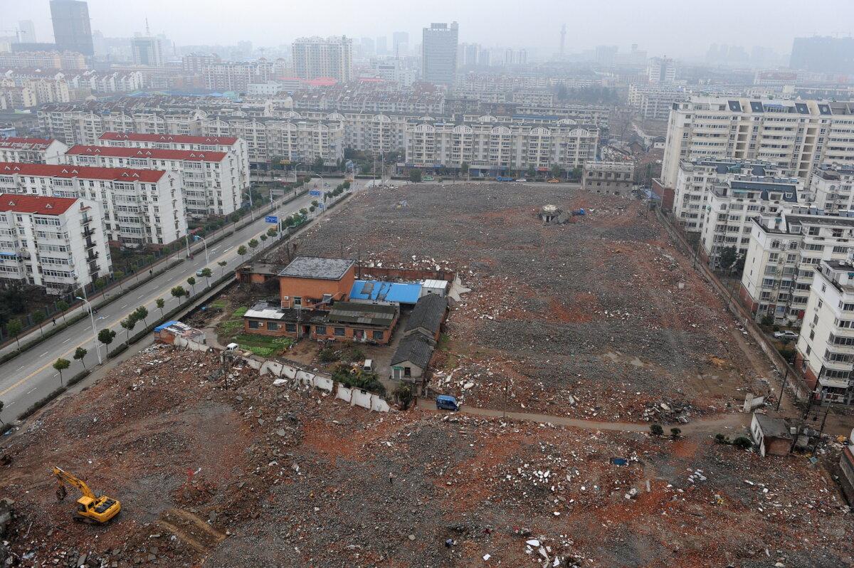 Chinese workers clear a piece of land to make way for the construction of a new highrise condominium in Hefei, east China's Anhui Province on March 6, 2010. (STR/AFP via Getty Images)