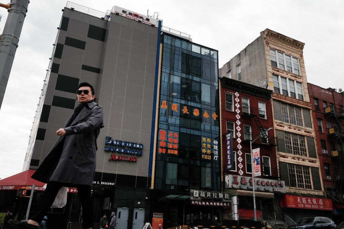 People walk by a building (C) that is suspected of being used as a secret police station in Chinatown for the purpose of repressing dissidents living in the United States on behalf of the Chinese regime, in lower Manhattan in New York on April 18, 2023. (Spencer Platt/Getty Images)