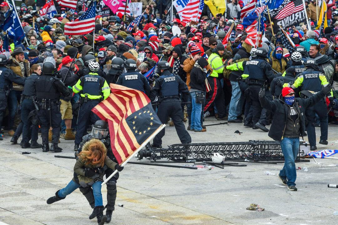 Police try to hold back protesters on the West Plaza of the U.S. Capitol on Jan. 6, 2021. (Roberto Schmidt/AFP via Getty Images)