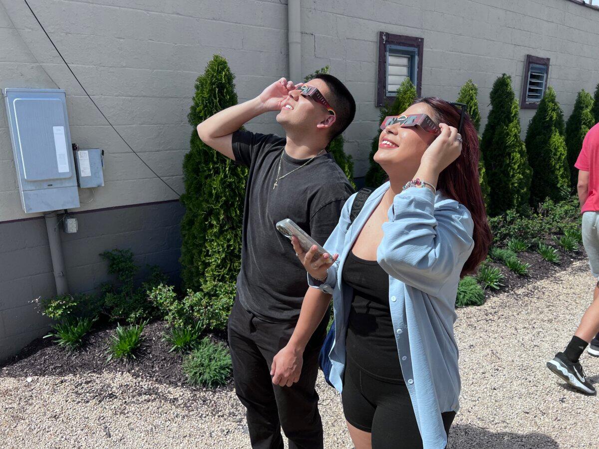 Una pareja observa una etapa temprana del eclipse solar total en Indianápolis, Indiana, el 8 de abril de 2024. (Lawrence Wilson/La Gran Época)