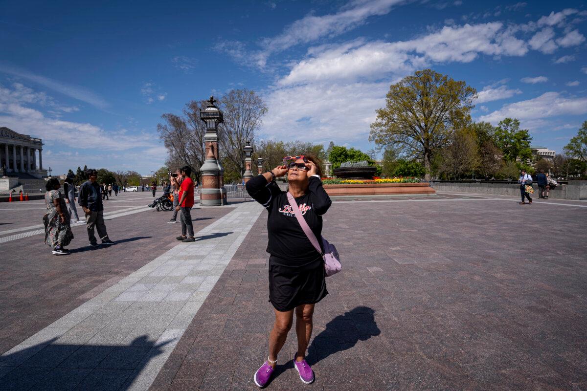 People watch the solar eclipse in Washington on April 8, 2024. (Madalina Vasiliu/The Epoch Times)