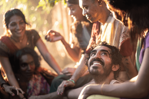 Kid (Dev Patel, seated, center) surrounded by trans-gurus, in "Monkey Man." (Universal Pictures)