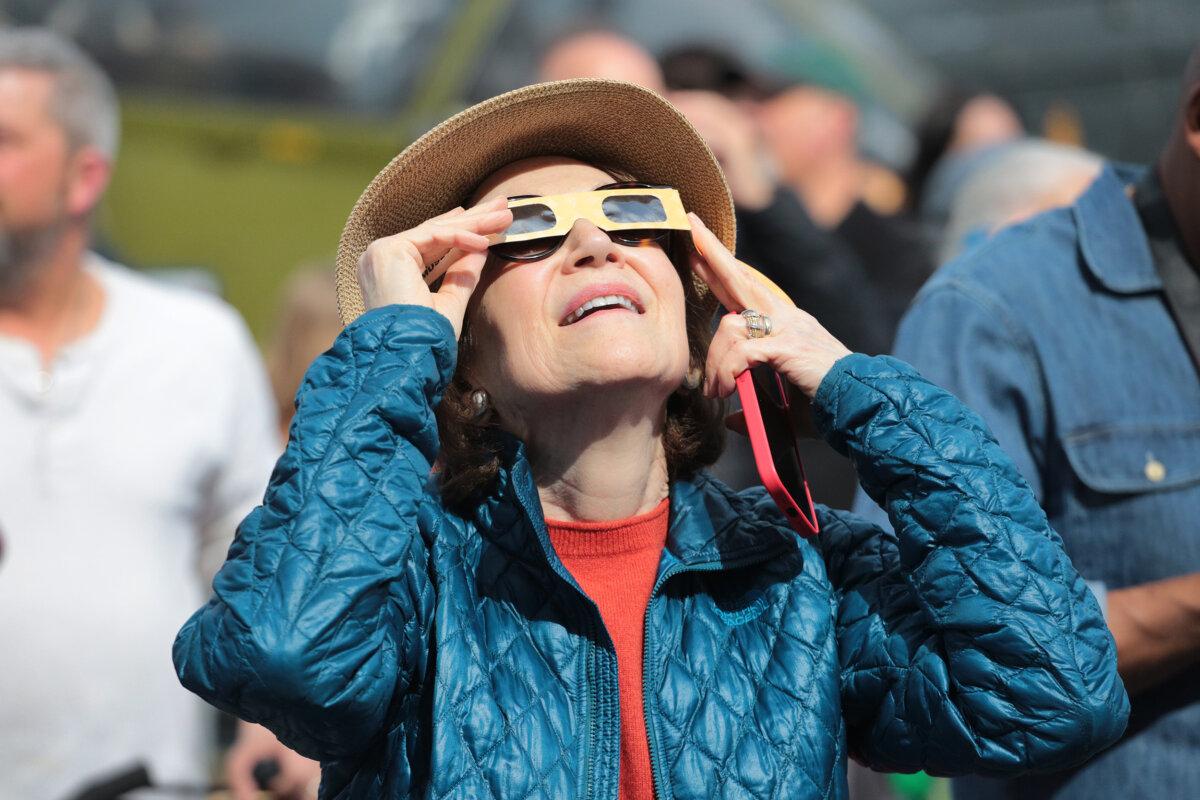 Watching the solar eclipse with approved safety glasses in New York on April 8, 2024. (Richard Moore/The Epoch Times)