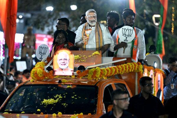 Narendra Modi (C), India's Prime Minister and leader of the ruling Bharatiya Janata Party (BJP) holds the party symbol during a road show at an election campaign held ahead of the country's upcoming general elections, in Chennai, on April 9, 2024. (R. Satish Babu/AFP via Getty Images)