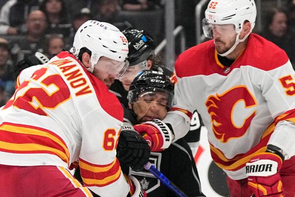 Quinton Byfield of the Kings is sandwiched between Flames players Daniil Miromanov (L) and MacKenzie Weegar during an NHL game in Los Angeles on April 11, 2024. (Mark J. Terrill/AP Photo)