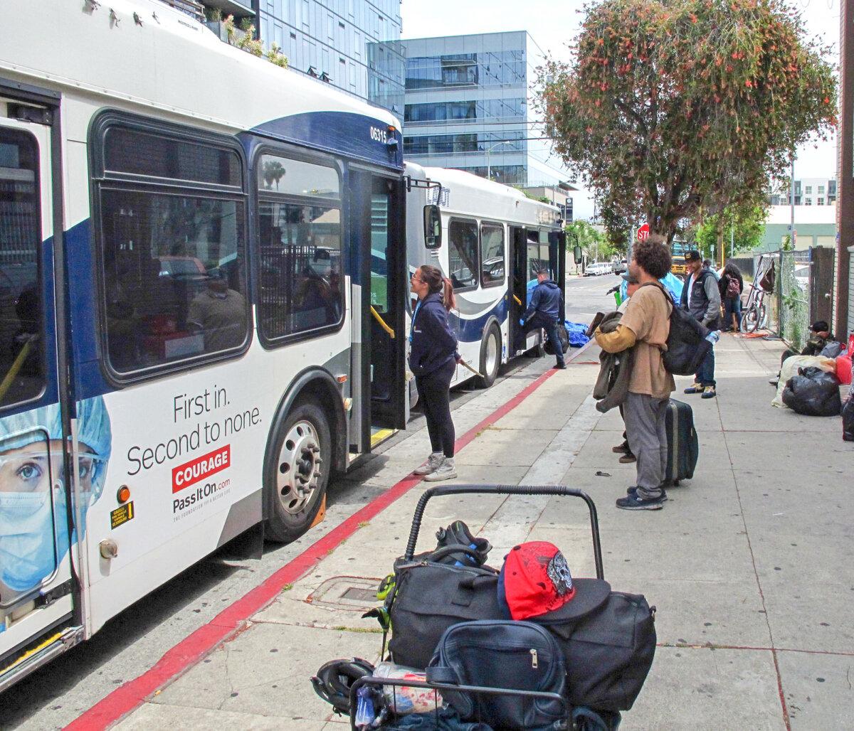 Homeless people get on a bus to go to a hotel as part of the Inside Safe program in Los Angeles. (Courtesy of Keith Johnson)