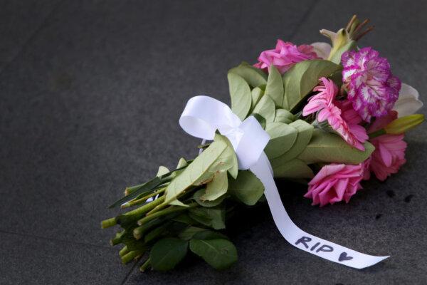 Flowers with a ribbon reading "R.I.P" are seen at an entrance to Westfield Bondi Junction, in Sydney, Australia, on April 14, 2024. (Lisa Maree Williams/Getty Images)