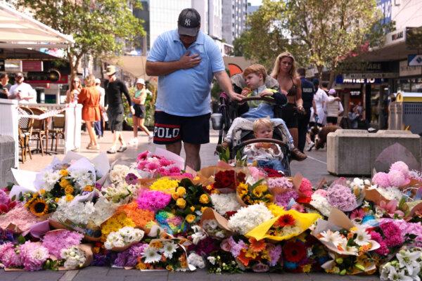 A man reacts after leaving flowers outside the Westfield Bondi Junction shopping mall in Sydney, Australia, on April 14, 2024. (David Gray/AFP via Getty Images)