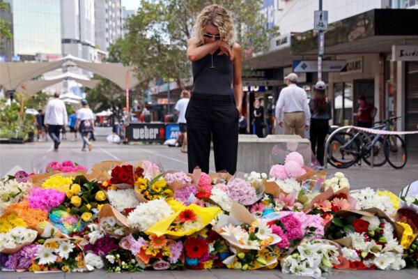 A woman reacts after leaving flowers outside the Westfield Bondi Junction shopping mall in Sydney, Australia, on April 14, 2024. (David Gray/AFP via Getty Images)