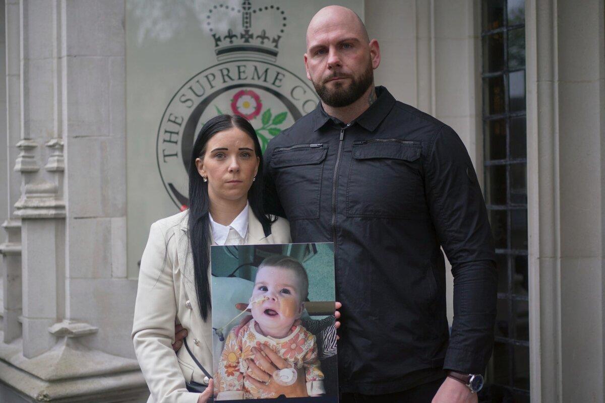 Dean Gregory and Claire Staniforth hold a photo of Indi Gregory, outside the Supreme Court in London on April 15, 2024. (Yui Mok/PA)