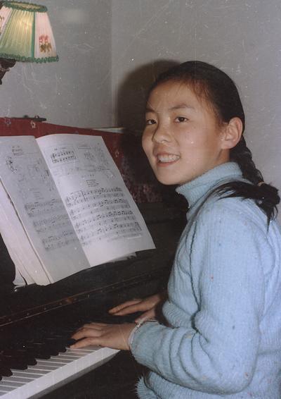 A young Zhu Ling playing piano before she was poisoned. (Courtesy of Help Zhuling Foundation)