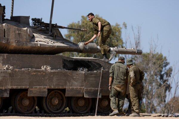 Israeli soldiers stand next to a tank, near the Israel-Gaza border, amid the ongoing conflict between Israel and the Palestinian terrorist group Hamas, in Israel, on April 15, 2024. (Amir Cohen/Reuters)