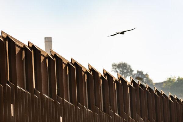 A bird flies over the U.S. border wall from San Ysidro, Calif., on April 11, 2024. (John Fredricks/The Epoch Times)