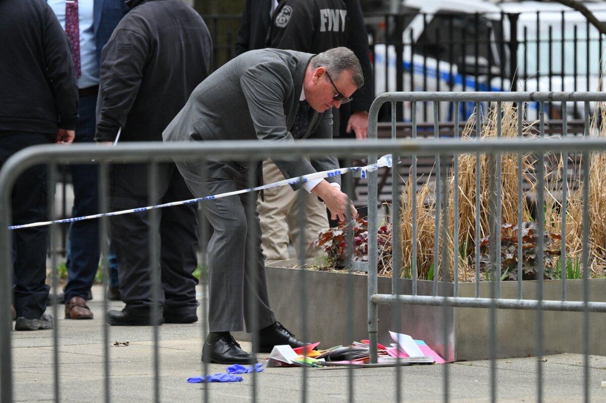 An investigator takes pictures of pamphlets thrown by Max Azzarello after he set himself on fire at the park across from Manhattan Criminal Court in New York City on April 19, 2024. (Angela Weiss/AFP/Getty Images)