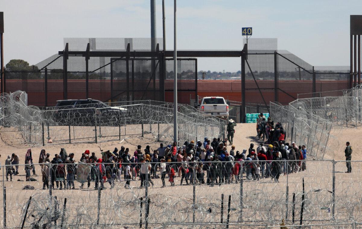 Illegal immigrants line up to be transferred by U.S. Border Patrol after having crossed the Bravo River in El Paso, Texas, as seen from Ciudad Juarez, Chihuahua State, Mexico, on April 18, 2024. (Herika Martinez/AFP via Getty Images)